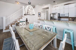 A modern kitchen with white cabinetry, a granite countertop, and stainless steel appliances.