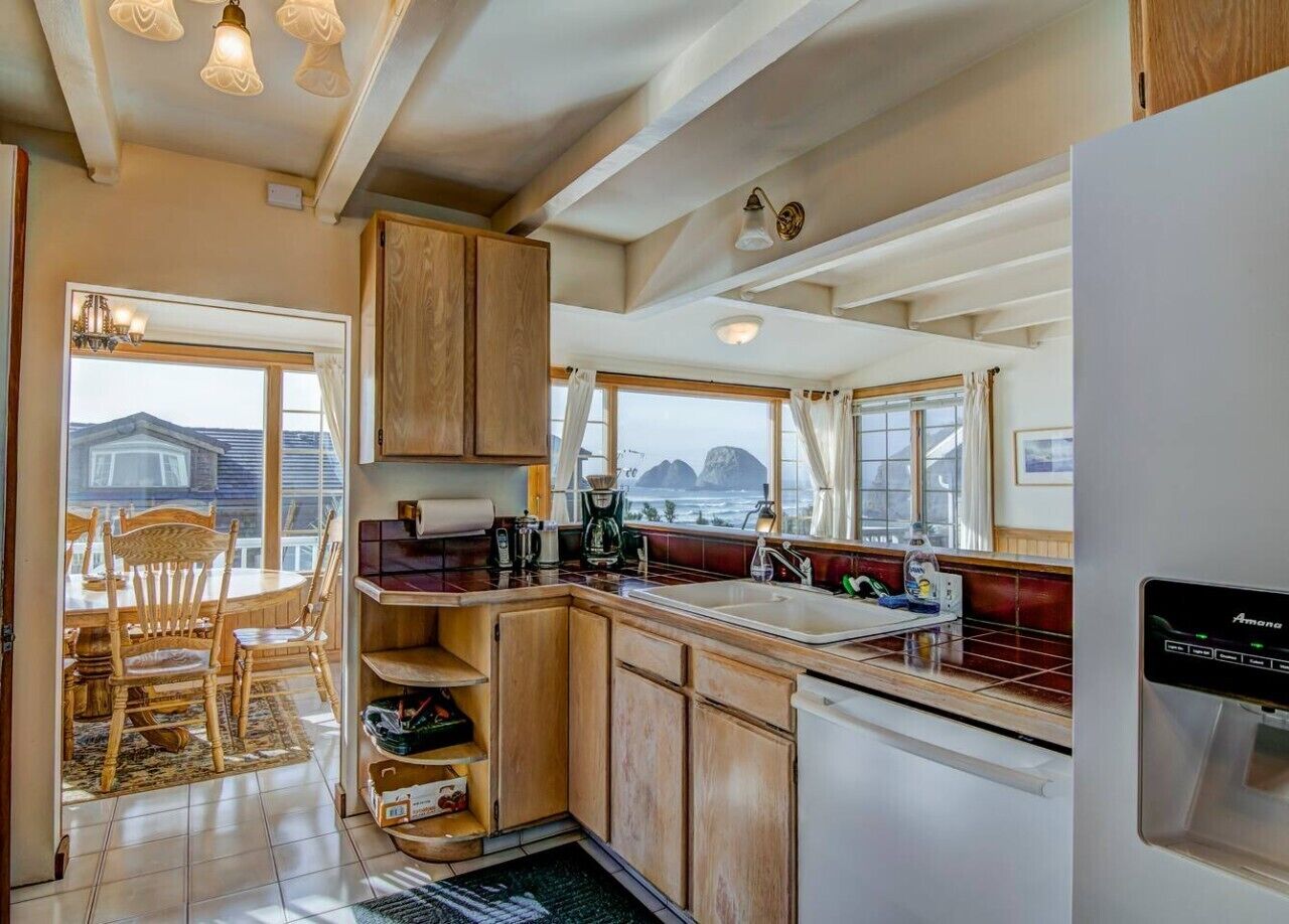 A kitchen with wooden cabinets, a sink, and a refrigerator.