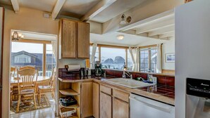 A kitchen with wooden cabinets, a sink, and a refrigerator.