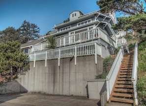 A multi-story house with a wooden staircase leading to a balcony. - Beach Treasure- Ocean view~ Oceanside (Oceanside)