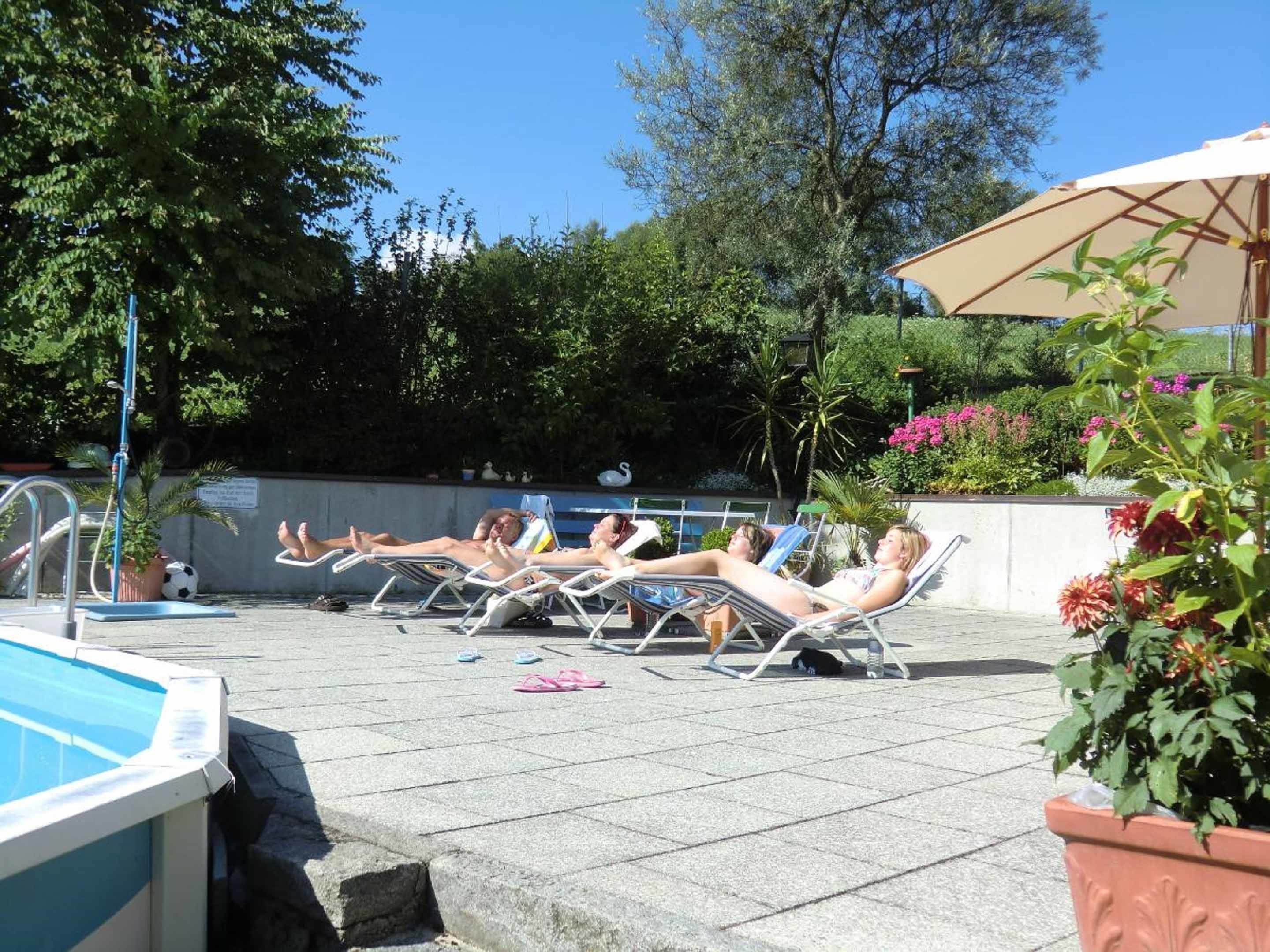 A pool area with lounge chairs and a pool.