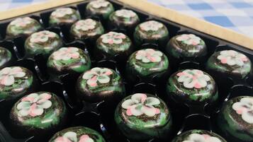 Una bandeja de pasteles redondos con glaseado rosa y blanco sobre un mantel a cuadros.
