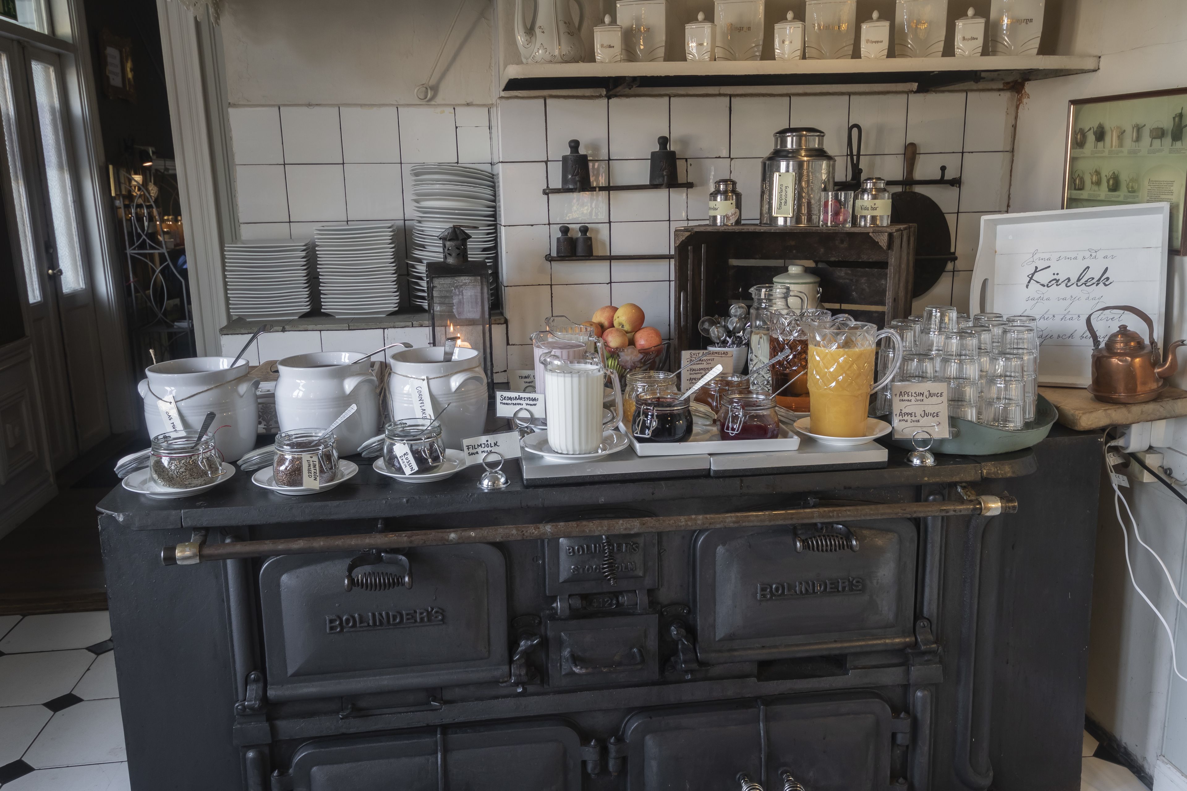 Una encimera de cocina con diversos objetos, como frascos, una jarrón y un letrero con texto.