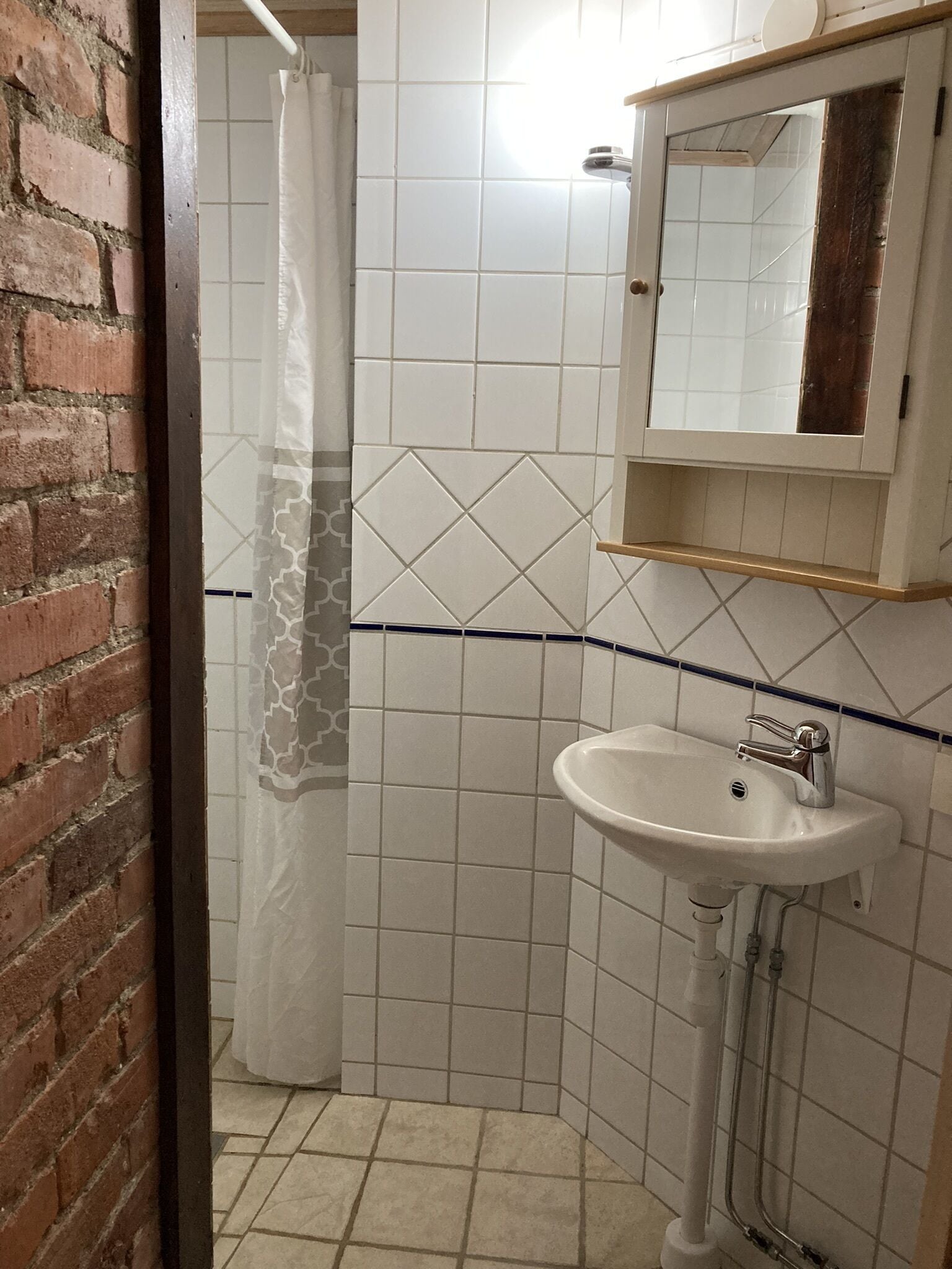 A bathroom with a white sink, a mirror, and a shower curtain.