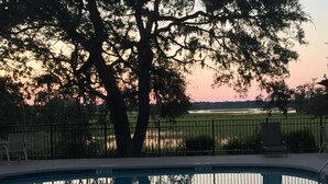 Uima-allas, josta avautuu näkymä auringonlaskuun ja taustalla näkyviin puihin.