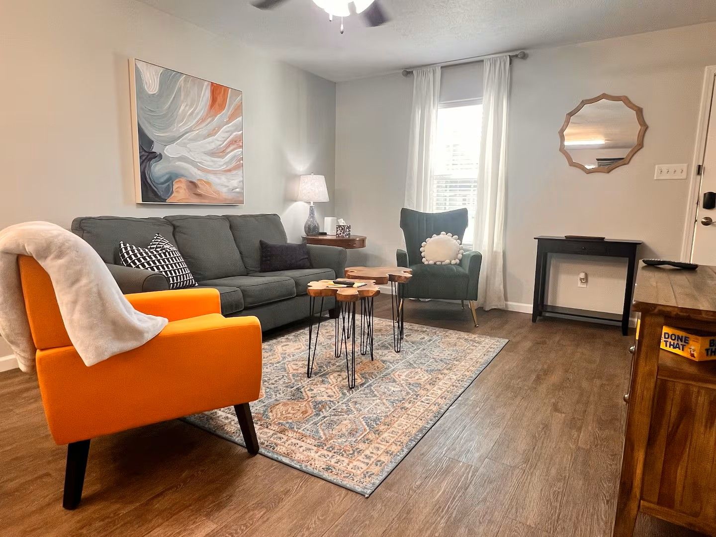 Una sala de estar con sofá, sillón, mesa de centro y alfombra.