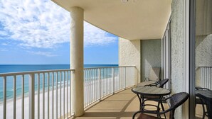 A balcony with a view of the beach and ocean, featuring a table and chairs. - Tower 1, 10th Floor 1Bdr!! Beautiful Unit with Awesome Views! (Panama City Beach)