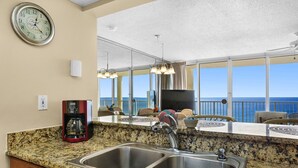 A kitchen with a granite countertop, stainless steel sink, and a coffee maker. - Tower 1, 10th Floor 1Bdr!! Beautiful Unit with Awesome Views! (Panama City Beach)