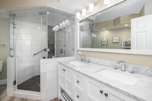 A bathroom with a glass-enclosed shower, a large mirror, and a double sink vanity. - Stay @ Peaches & Cream on Folly Beach (Folly Beach)