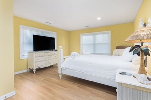 A bedroom with a bed, a dresser, a television, and a lamp. - Stay @ Fun in the Sun! (Folly Beach)