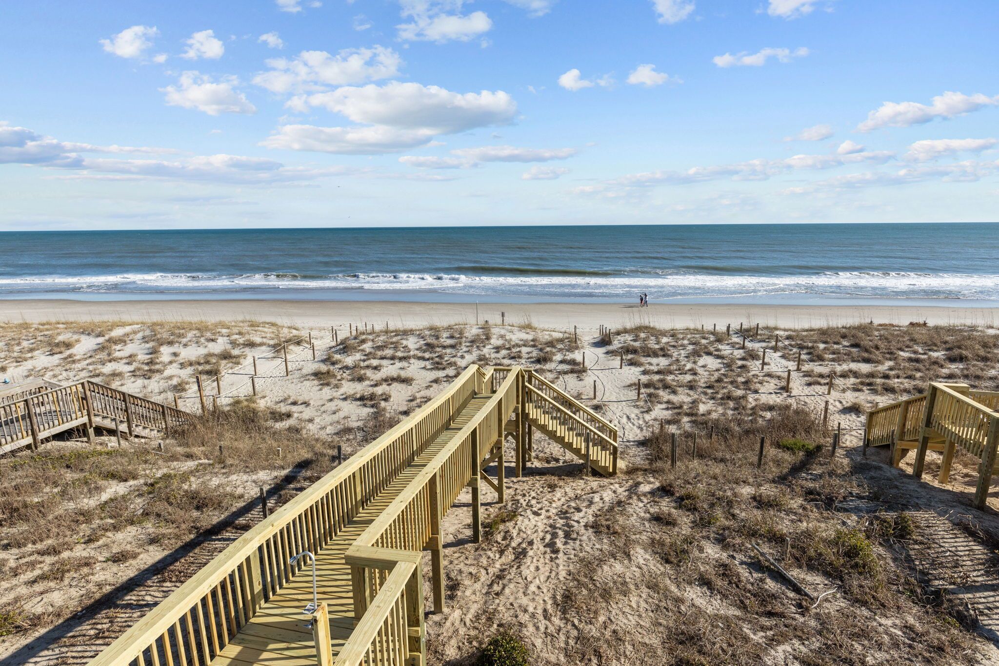 A beach with wooden boardwalks leading to the shore.