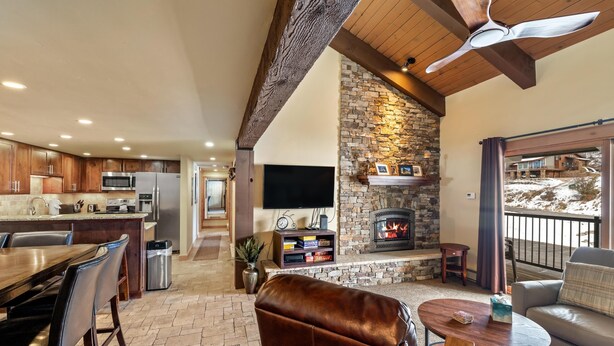 A spacious living area with a stone fireplace, a dining table, and a comfortable seating arrangement. - ✨ Newly Remodeled Sleeps 8 Pool, Hot Tubs,Fireplace, Private Deck (Steamboat Springs)