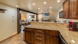 A spacious kitchen with granite countertops, wooden cabinets, and a built-in dishwasher. - ✨ Newly Remodeled Sleeps 8 Pool, Hot Tubs,Fireplace, Private Deck (Steamboat Springs)