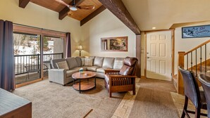 A spacious living room with a large sectional sofa, a wooden chair, and a round coffee table. - ✨ Newly Remodeled Sleeps 8 Pool, Hot Tubs,Fireplace, Private Deck (Steamboat Springs)