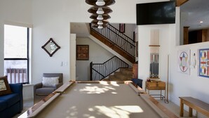 A pool table in a room with a staircase, a blue sofa, and a wooden bench. - Luxury home less than a mile from Deer Valley with free shuttle to and from DV (Park City)