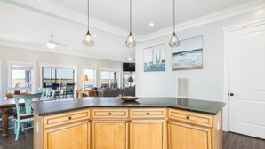 Una cocina amplia con armarios de madera, una isla grande e iluminación colgante.