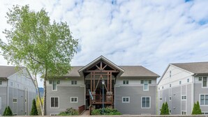 A multi-story building with a central entrance, balconies, and a parking lot. - Hawks Peak South 221-Mtn Condo, Near High Country Attractions, ZipLining, Hiking (Seven Devils)