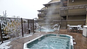 Zona de jacuzzi con piscina de 0.9 metros, rodeada por una valla y mobiliario para exteriores.