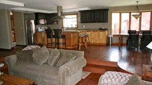 A spacious living room with a sofa, a coffee table, and a dining area with chairs and a table. - Private Ranch House Resort (Templeton)