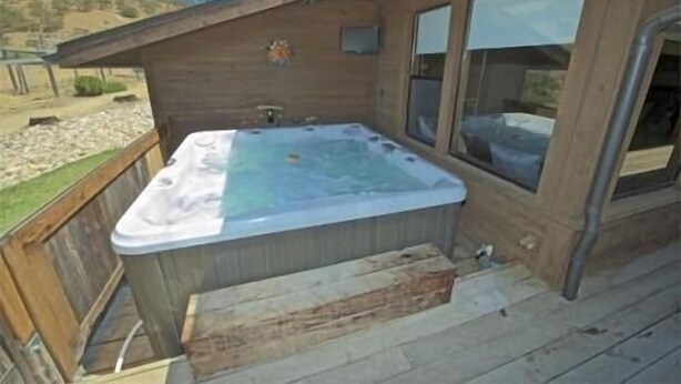 A hot tub on a wooden deck with a view of the surrounding landscape. - Private Ranch House Resort (Templeton)