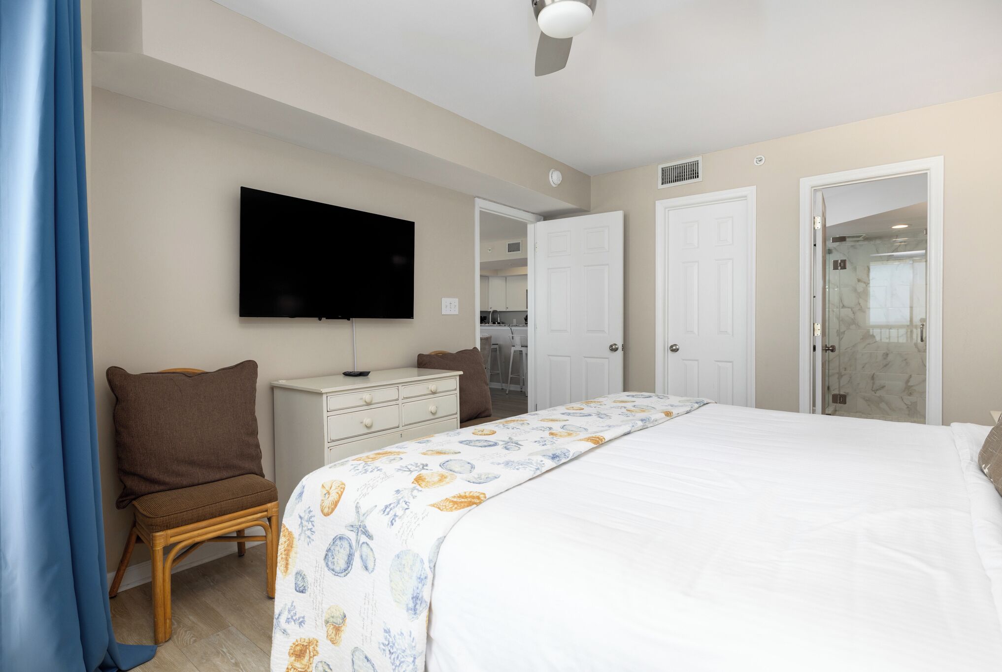 Un dormitorio con una cama, televisor, armario y puerta que da a un baño.