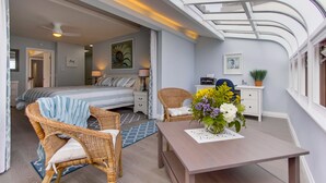 A modern bedroom with a skylight, a bed, a desk, and wicker furniture. - Right On The Beach! Exquisitely Remodeled 3BR/3BA . Perfect For Families. (San Diego)