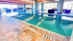 An indoor swimming pool with blue-tiled walls, a wooden ceiling, and a tiled floor marked with "5 FT." and "NO DIVING" signs. - Beach Club 1005 - 𝑨𝒒𝒖𝒂 𝑶𝒂𝒔𝒊𝒔 (Pensacola Beach)