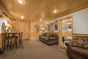 Un intérieur en bois comprenant un canapé, une table à manger avec des chaises et un miroir.