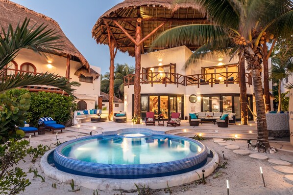 A resort with a swimming pool, outdoor seating, and a two-story building with balconies.