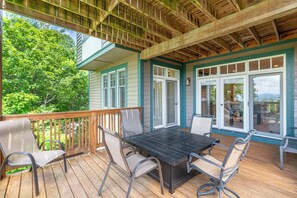 An outdoor deck with a table and chairs, a wooden railing, and a view of trees. - Townhome R5B- Mtn Home/View, Foosball, Indoor/Outdoor Pools & Hot Tub, Fireplace (Banner Elk)