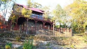 Un bâtiment en pierre avec un toit rouge et un balcon en bois.