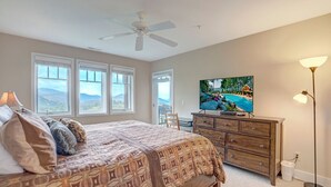 A bedroom with a bed, a dresser, a television, and a ceiling fan. - Wintergreens R1012- Mtn Condo/View, Gated Resort, Indoor/Outdoor Pools & Hot Tub (Boone)