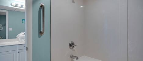 Un baño con bañera, ducha y barandilla.