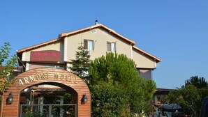 Un edifici de dues plantes amb un cartell que diu 'ARMONI MOTEL' a l'entrada.
