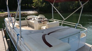 Un bote con zona de estar cubierta, timón y tabla para wakeboard.