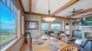 A dining area with a wooden table and chairs, a ceiling fan, and a view of the outdoors. - Chalakee Lodge CH-3- Mountain View, Gated Resort, Indoor/Outdoor Pools & Hot Tub (Boone)