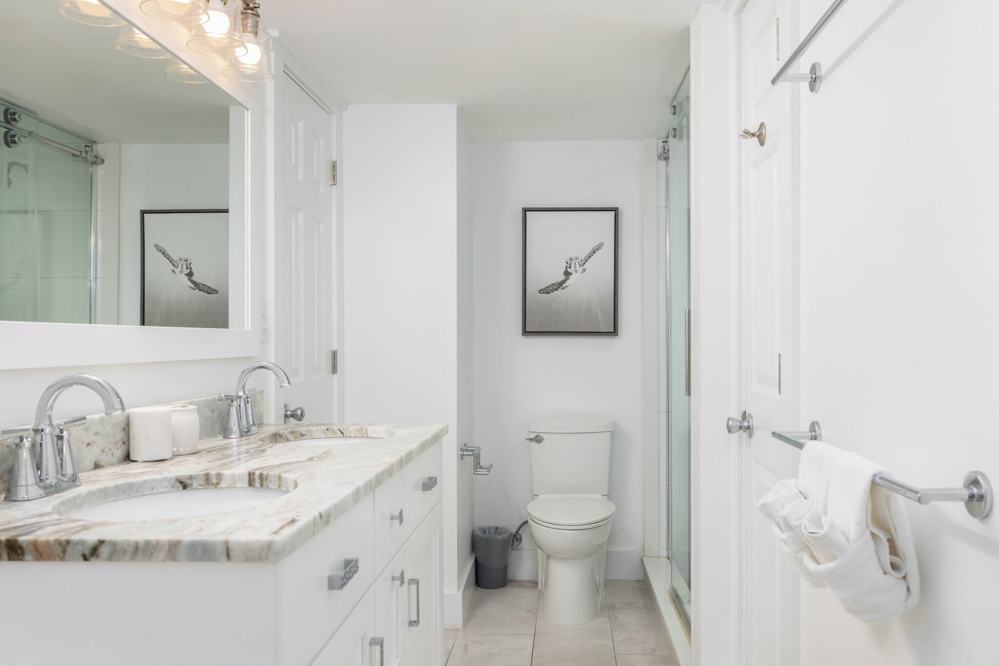 Un baño moderno con un lavabo de mármol, un inodoro y un cuadro en la pared.