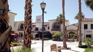 Un patio con palmeras, un farol y un edificio con un letrero que dice "Old Town".