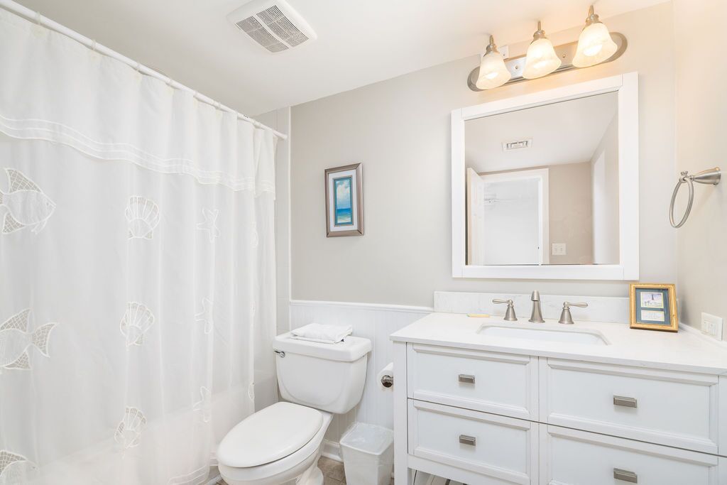 Une salle de bain avec des toilettes, un lavabo et un miroir.