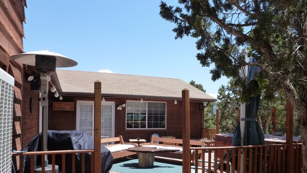 A wooden deck with outdoor furniture, a hot tub, and a pool.