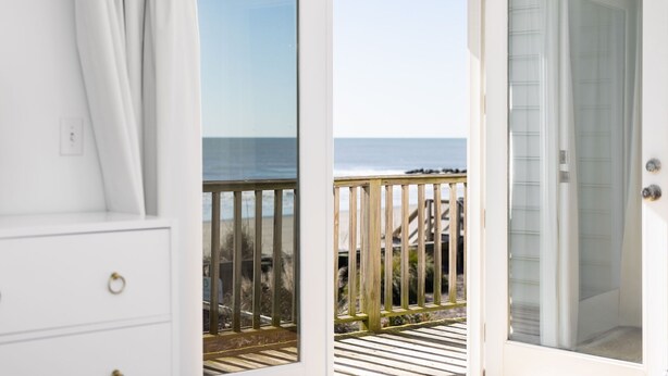 A room with a view of the beach and ocean through a glass door. - Stay @ Sea Cookie! Classic, Updated Beach Home (Folly Beach)
