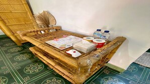 A room with a woven bench, a wall-mounted fan, and a patterned floor.