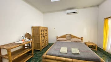 Una habitación con una cama, un armario de madera, una mesita y una estantería.