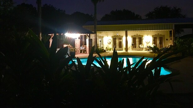A pool area with a house in the background.