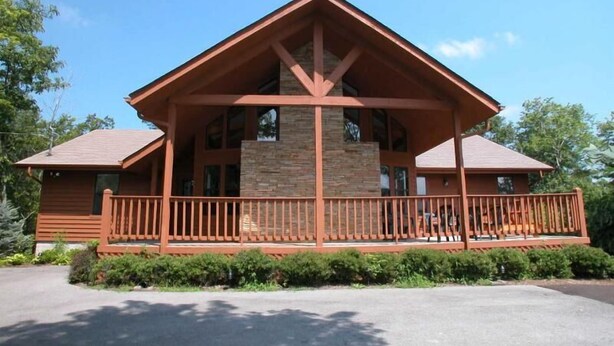 A lodge with a prominent stone facade, a covered porch, and a symmetrical roofline.