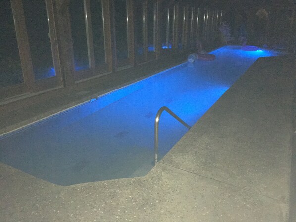 A swimming pool with a metal ladder, surrounded by a concrete deck. - Retro Ranch With Private Indoor Pool & Sauna St Louis, MO (Saint Louis)