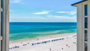 Une vue sur la plage depuis un immeuble, avec un ciel dégagé.