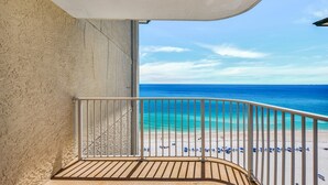 Un balcon avec vue sur une plage et l’océan.