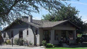 A two-story house with a brick facade, a front porch, and a bicycle parked outside. - 1927 Restored Downtown Phx Historic Bungalow close to Medical & Sports. (Phoenix)