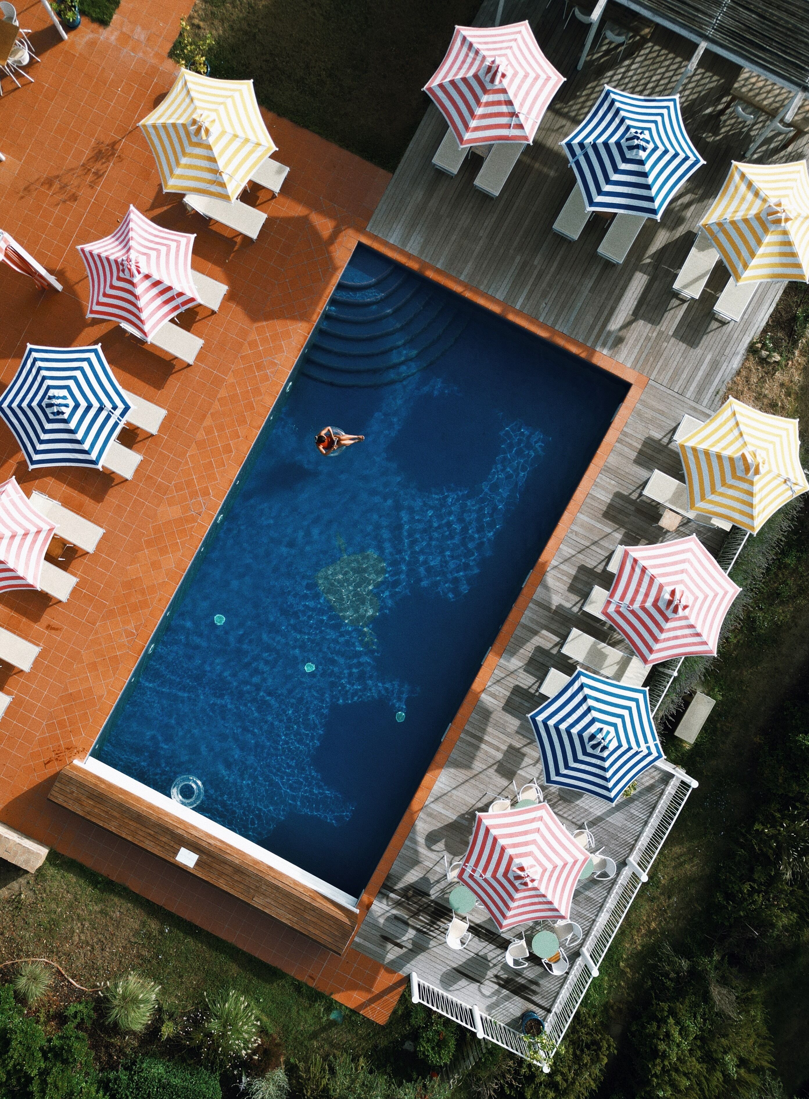 Una piscina al aire libre, sillones reclinables de piscina